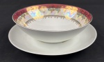Schmidt. Molheira em porcelana branca, com larga faixa furta-cor, borda em tom vinho e profusa ornamentação dourada. Manufatura no verso. Medidas: 6 x 19 cm.