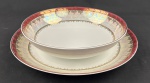 Schmidt. Saladeira e medalhão em porcelana branca, com larga faixa furta-cor, borda em tom vinho e profusa ornamentação dourada. Manufatura no verso. Medidas: 7 x 26 cm e 4 x 32 cm.