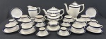 Thomas Hughes & Son Ltd, Staffordshire, Inglaterra - Selo `Unicorn Trade Mark`, c. 1910–1930. Serviço para chá e café em faiança Inglesa, esmaltado na cor branca e decorado com filetes duplos em azul-cobalto nas bordas Padrão Bleu Mazarine / Blue de Roi. Composto de Bule de chá, bule de café, leiteira, açucareiro, manteigueira, 10 xícaras de chá com 12 pires e 6 xícaras de café com seus pires. Manufatura no verso. Medindo:20,5 x 24 cm, 15 x 27 cm, 15x 14 cm, 12 x 19 cm, 7 x 13 cm. Craquelê. Manchas no bule, manteigueira e 4 xícaras.