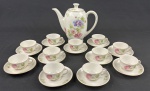 Königszelt, Poland. Conjunto em porcelana polonesa datado do período pós-guerra (c. 1945–1957), esmaltada em tom branco , decorado com delicados florais policromados em tons de rosa, roxo e verde, além de filetes em ouro nas bordas e alças. Composto de bule e 11 xícaras.  Medindo: 20 x 28 cm. Uma xícara com ínfimo bicado