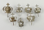  Arte Sacra / Prataria. 06 coroas sacras imperiais e 01 pingente em formato de coroa com argola de suspensão, prata recortada, moldada e ornamentadas artesanalmente. Todas as 6 coroas contam com hastes inferiores (pinos) de fixação para as cabeças das imagens sacras. Aproximadamente 2,5 cm x 3,0 cm (contando o pino). Apresenta oxidação.