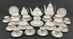 REAL - Serviço de chá e café, em porcelana nacional, adornadas por rico trabalho e filetes em prata. Composto por 7 xícaras para chá com 11pires, 8 para café com seus respectivos pires, 1 bule, 1 chaleira, 1 leiteira, 1 açucareiro e 1 manteigueira. Peças em bom estado de conservação. Bule café (24x17 cm); Bule chá (17x20 cm); Leiteira (14x11 cm); Açucareiro (12x10 cm) e manteigueira - 7x15 cm