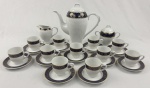 Trahl,Style Bavaria. Serviço para café em porcelana, esmaltada na cor branca, borda em azul cobalto com rica decoração de arabescos e volutas em ouro. Composto de bule, leiteira, açucareiro e 11 xícaras com seus pires. Manufatura no verso. Medindo: 23 x 25 cm, 12 x 13 cm, 10x 12 cm. Um pires com restauro.