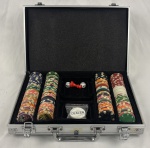 Conjunto para pôquer acondicionado em maleta rígida de alumínio, com interior revestido e compartimentado, contendo fichas plásticas em diversas cores e valores, marcadores `Dealer`, `Big Blind` e `Little Blind`, dois dados e marcador central. Apresenta marcas de uso.