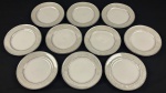 Schmidt, Voyage. Dez pratos para pão em porcelana esmaltada na cor branca, borda decorada e filetes em prata. Manufatura no verso. Medindo: 15 cm.