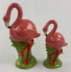 Conjunto de 2 esculturas representando flamingos em cerâmica esmaltada e vitrificada nas cores rosa e verde. Medindo: 30 x 15 cm e 22 x 12 cm.