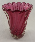 MURANO. Vaso em vidro artístico doublé rubi, com corpo canelado e torcido, recortes revelando o translúcido e borda ondulada em formato de pétalas. Medindo: 24 x 18 cm.