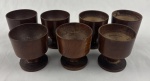 Conjunto de sete copos de ovos (egg cups) feito de madeira torneada com acabamento rústico marrom. Medindo; 7 x 6,5 cm.