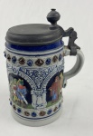 Caneca de chope alemão tipo Stein, em cerâmica esmaltada, da coleção Peter Dillr Collection Original Gerz (Western Germany), identificado como Limited Edition, nº 18. Apresenta decoração em alto-relevo e policromia, com cenas figurativas de inspiração medieval. Medindo: 14,5 x 9 cm