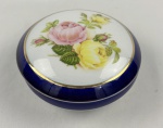 PÂTE LIMOGES - Caixa porta joias em porcelana francesa,  decorada com motivo floral, faixa azul cobalto e frisos a ouro. Apresenta bicado.