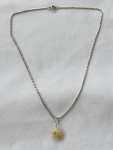 Conjunto em prata de lei, composto por gargantilha em malha italiana e pingente em osso com marfim, representando elefante. Medindo: 40 cm de extensão. Peso: 4 g.