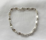 Pulseira unissex em prata de lei, com elos entrelaçados. Medindo: 20 cm de extensão. Peso: 5,2 g.