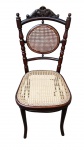 Cadeira THONET em madeira de tonalidade escura, com estrutura torneada e curvada, espaldar recortado encimado por ornamentos entalhados, medalhão circular e assento em palhinha trançada sintética. Apresenta marcas de uso. Medindo: 96 x 40 x 40 cm.