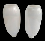 Duas cúpulas para luminária em opalina branca, de formato alongado, com corpo abaulado e aberturas nas extremidades. Medindo: 17 x 5 cm de diâmetro, cada.