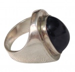 Anel em prata, ornamentado por grande pedra lilás de formato retangular com cantos arredondados e lapidação cabochão, emoldurada por estrutura lisa e elevada. Laterais com acabamento texturizado. Aro: 21. Peso: 16,8 g.