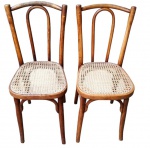 THONET. Duas antigas cadeiras em madeira curvada, com espaldar vazado, assentos em palhinha sintética e pés arqueados, unidos por travessas. Em bom estado de conservação, apresentando discretas marcas do tempo e de uso. Medindo: 85 x 38 x 36 cm, cada. 