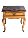 MOBILIÁRIO, uma (1) mesa lateral de estilo clássico, confeccionada em madeira clara, com tampo retangular decorado por mapa-múndi sob superfície protetora, uma gaveta frontal com puxador metálico ornamentado, saia recortada e quatro pés curvos tipo cabriolet, medindo 54,5x52,5x38cm.