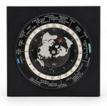 RELÓGIO, um (1) relógio de horário mundial, marca DDEX QUARTZ, com mostrador circular giratório, escala de 24 horas, indicação de fusos horários de diversas cidades do mundo e representação cartográfica do globo terrestre ao centro. Estrutura quadrada em plástico na cor preta, com detalhes em branco e vermelho. Apresenta sinais de uso e marcas do tempo. Funcionamento não testado e sem garantia de funcionamento, medindo 15x15cm.