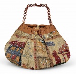 ACESSÓRIO FEMININO, uma (1) bolsa de ombro confeccionada em estopa, com decoração em padrões geométricos e motivos étnicos multicoloridos, aplicações de lantejoulas e paetês, acabamento superior em tecido marrom, fechamento por cordão e alça de ombro formada por elos circulares em madeira. Apresenta sinais de uso, medindo 30x39cm.