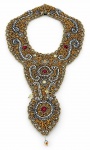 BIJUTERIA, um (1) colar estilo babador, ricamente ornamentado com aplicação de miçangas, canutilhos e pedrarias em tons dourado e prateado, com detalhes em pedras vermelhas e conta pendente na extremidade. Peça de efeito decorativo e vistoso. Fecho em gancho, apresentando sinais de uso e leves desgastes, medindo 48x24cm.