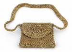 ACESSÓRIO FEMININO, uma (1) bolsa de ombro confeccionada em metal dourado, com estrutura formada por elos entrelaçados em trama tipo malha metálica, formato retangular, aba frontal e alça longa no mesmo material. Apresenta sinais de uso, medindo 17x21cm.