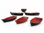 DIVERSOS, conjunto com seis (6) peças para servir comida chinesa, sendo cinco (5) barcas de tamanhos variados e uma (1) tigela circular com decoração de folhas douradas. Peças em material rígido possivelmente charão, com acabamento externo preto e interior vermelho, ao estilo oriental. Apresentam sinais de uso e marcas do tempo, algumas com pequenos bicados. No estado. Barcas medindo 30x14cm e tigela 6x12cm.