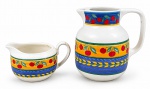VISTA ALEGRE, duas (2) peças confeccionadas em faiança portuguesa vitrificada na tonalidade branca, linhas "FRUIT FANTASY", decoradas por frutos, folhagens em policromia sobre fundo amarelo e azul, sendo: A) 1 jarra, medindo 19x18x8,5cm, sinais de craquele e B) 1 leiteira, colada na alça, medindo 9,5x17x11cm.