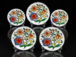 PORCELANA INTER-AMERICAN, conjunto para bolo com cinco (5) peças confeccionadas em porcelana na tonalidade branca, decorada por elementos florais e vegetalistas em policromia com falhas na pintura e borda em ondulações, sendo: A) 1 prato para bolo, medindo 27cm e B) 4 pratos para sobremesa, medindo 19cm.