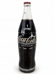 COLECIONISMO, uma (1) garrafa vintage de COCA-COLA, capacidade de 1 litro, em vidro transparente, com logotipo original da marca em branco, tampa metálica vermelha tipo coroa, aparentemente lacrada e contendo líquido. Apresenta sinais de uso, desgastes na impressão e marcas do tempo. Peça destinada ao colecionismo, não recomendada para consumo. No estado.