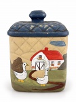 FAIANÇA, uma (1) biscoiteira confeccionada em faiança com pintura representando fazenda, decorada por casario e patos em policromia, tampa na cor azul com falhas na pintura, assinado ART MILA, bicados na borda, medindo 18x13x11cm.