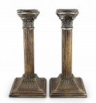 METAL INGLÊS, par (2) de castiçais confeccionados em metal espessurado a prata, base escalonada com borda em perolados, cinzelada em caneluras, bobeche ricamente decorada por elementos vegetalistas e perolados em recortes, apresentando falhas na prateação, medindo 20,5cm de altura. Falhas na prateação.