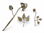 METAL PRATEADO, duas (2) flores decorativas confeccionadas em metal espessurado a prata com falhas na prateação, ladaeada por folhagens, pétalas em recortes, maior com parte necessitando solda, vide foto, medindo 23cm de comprimento e menor 11cm.