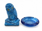 ESCULTURA e VIDRO, duas (2) peças, sendo: A) 1 escultura confeccionada em porcelana vitrificada na tonalidade azul representando coruja, apresentando bicado na orelha, medindo 18cm de altura e B) 1 cinzeiro confeccionado em vidro prensado na tonalidade azul, apresentando bicado, medindo 15cm de diâmetro.