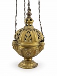 ARTE SACRA, um (1) turíbulo (objeto litúrgico utilizado para a queima de incenso em cerimônias religiosas), confeccionado em bronze, com corpo bojudo ricamente ornamentado em relevo, tampa vazada com motivos florais e vegetais, remate superior e sistema de suspensão por correntes. Assenta sobre base circular em ondulações, medindo sem corrente 18x9cm e altura com corrente 69cm de altura.