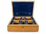 FAQUEIRO, uma (1) caixa para faqueiro confeccionado em madeira clara, interior com divisórias removíveis com forração em veludo na tonalidade azul, alças laterais em bronze cinzelada por caneluras e fitas cruzadas, apresenta sinais de uso e ranhuras externas, sem manufatura aparente, medindo 16,5x53x40cm.
