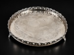 METAL PRATEADO, uma (1) salva circular confeccionada em metal espessurado a prata, fundo cinzelado por elementos vegetalistas, galeria em vazados, apoiado sobre 3 pés finalizados em garra, leves falhas na prateação, medindo 24cm de diâmetro.