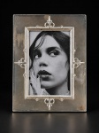 PRATA DE LEI CHRISTOFLE, um (1) porta retrato retangular confeccionado em PRATA DE LEI da manufatura CHRISTOFLE, contrastada STERLING, estilo art noveau, decorado por elementos em relevo, possui um verniz para proteger a peça, apresentando falhas no verniz, sinais de inchaço na madeira traseira, medindo 22x17cm, leves mossas.