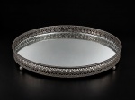 METAL PRATEADO, uma (1) salva circular confeccionada em metal escurecido com cinzelado floral em vazados e borda perolada, fundo em espelho com sinal de oxidação, apoiado sobre pés em bola, com ausência de 1, medindo 20,5cm.