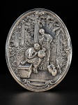 METAL PRATEADO, um (1) adorno de parede oval confeccionado em metal espessurado a prata, ricamente cinzelada por cena de artesanato em relevo com fundo em elementos vegetalistas e colunas em caneluras e borda em volutas, medindo 26,5x22cm.