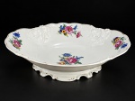 PORCELANA KPM, uma (1) fruteira oval confeccionada em porcelana polaca na tonalidade creme, decorada por flores e folhagens em policromia e elementos vegetalistas em relevo na pasta com recortes na base, medindo 8,5x32x23cm. Borda filetada em ouro com falhas na douração.