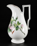 PORCELANA, uma (1) jarra de gomil confeccionada em porcelana na tonalidade branca, possivelmente europeia, decorada por flores e folhagens em poliocromia com filete na tonalidade preta, medindo 30x18,5x10,5cm.