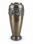 METAL PRATEADO, um (1) vaso confeccionado em metal com pintura fosca, faixa cinzelada por flores e folhagens e faixas horizontais em relevo, base circular escalonada, apresentando leves mossas, medindo 43x12cm.
