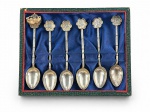 METAL PRATEADO, seis (6) colheres para café, em metal espessurado a prata, com cabos trabalhados em forma de bambu e terminais ornamentados com ideogramas chineses, sendo uma com motivo distinto em relevo. Acondicionadas em estojo revestido em tecido azul. Apresentam sinais de uso.