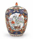 PORCELANA ORIENTAL, um (1) potiche confeccionado em porcelana oriental na tonalidade branca, ricamente decorada por elementos florais, vegetalistas sobre fundo azul e vermelho, aves em reserva, cães de fó e realces em ouro, medindo 32x20cm.