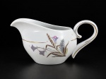 PORCELANA SCHMIDT, uma (1) leiteira confeccionada em porcelana na tonalidade branca com pintura de flores e folhagens em policromia e filetes em ouro, medindo 9x18x11cm.