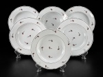 PORCELANAS, seis (6) pratos fundos confeccionados em porcelana na tonalidade branca, decorado por flores e folhagens em policromia com borda filetada a ouro, apresentando falhas na pintura e na douração, 1 com fio de cabelo na borda, medindo 23cm.