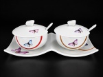 PORCELANA WOLFF - (2) Molheiras com presentoir em porcalana branca vitrificada , decoração zoomófica representando borboletas em policromia , medidas : 7 cm , medida do presentoir : 21 x 10 cm , acompanham colheres