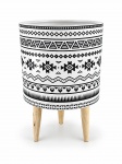 FAIANÇA , um (1) cachepô em cerâmica, de formato cilíndrico, na cor branca, decorado com motivos geométricos de inspiração étnica em preto, apresentando faixas ornamentais, losangos e desenhos estilizados. Apoiado sobre três pés em madeira natural. Medida : 32 x 20 cm
