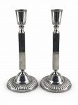 METAL PRATEADO /BRISTOL  - Par de castiçais para uma vela confeccionada em metal espessurado à prata , haste cilíndrica com base circular decorada com relevos e caneluras , medida : 23 cm