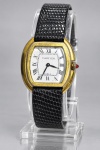 RELÓGIO, um (1) relógio de pulso CARTIER, de corda manual, caixa em metal dourado de formato tonneau, mostrador branco com algarismos romanos, ponteiros centrais e inscrição CARTIER  PARIS. Coroa com aplique vermelho, pulseira preta. Movimento mecânico marcado 17 SEVENTEEN JEWELS. Fundo gravado e numerado "6207. Caixa, mostrador e pulseira apresentando desgastes, riscos e sinais do tempo. Peça no estado. Não testado e sem garantia de funcionamento, foto da maquina na extra, caixa medindo 2,5x3,5cm.